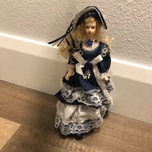 Porcelain doll ornament with blue dress and curly hair